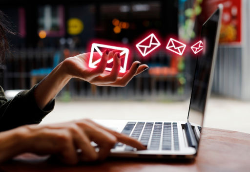 A woman uses a laptop and holds the images of red outlined envelopes in her hands, symbolizing the handling of email bounces.